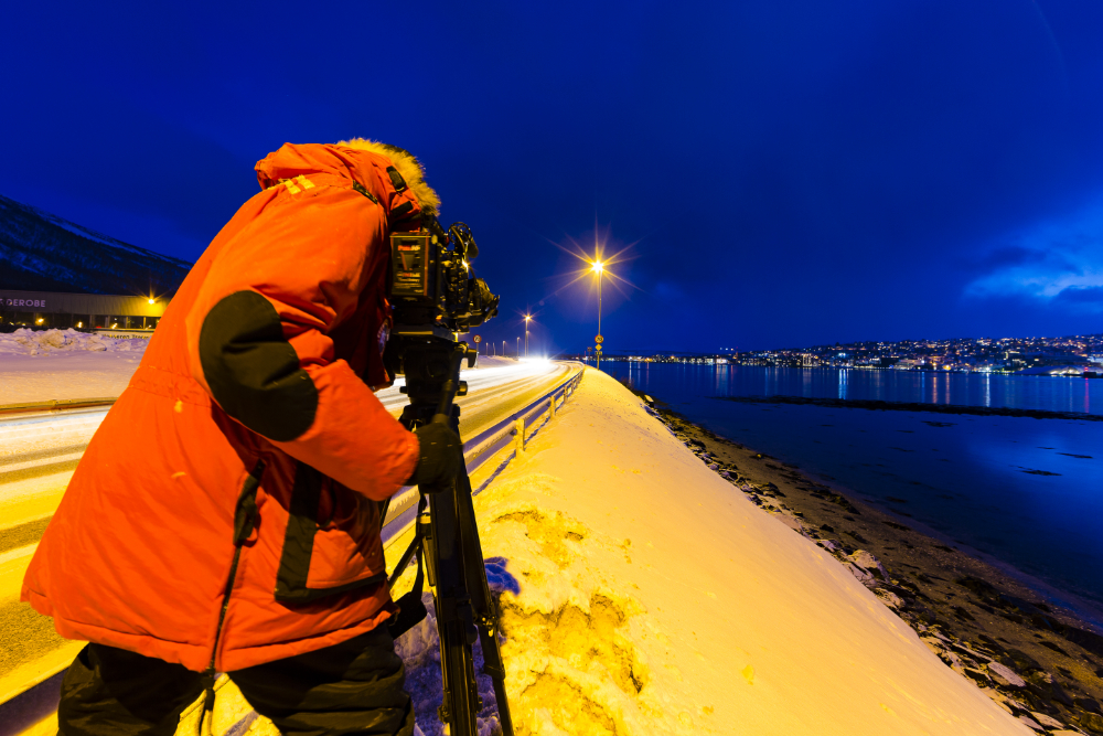 Tromso, Norway. Cameraman Alister Chapman filming beside highway at night.